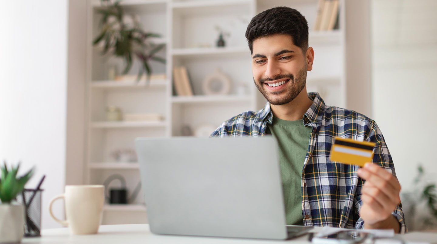 Jeune professionnel de 26-28 ans consultant son application bancaire sur smartphone dans un open space moderne lumineux, tenue business casual